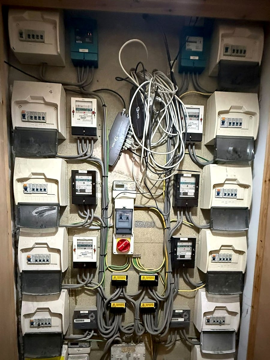 Communal meter cupboard with a bank of meters and consumer units, opened up for fault finding